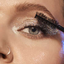 Woman applying volumising mascara